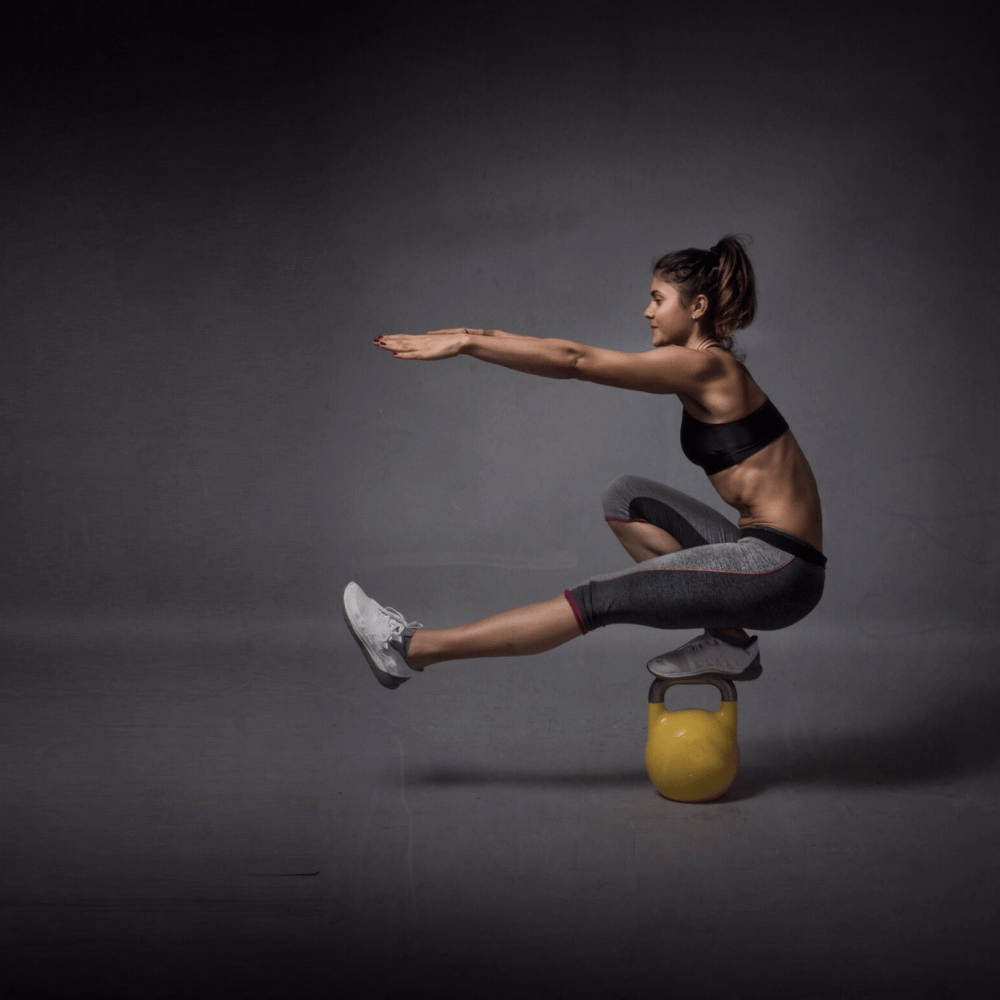 Frau bei einbeiniger Kniebeuge auf Kettlebell – Functional Training für Frauen in der Fitness Lounge Hamburg